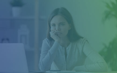 A bored child in front of a laptop.