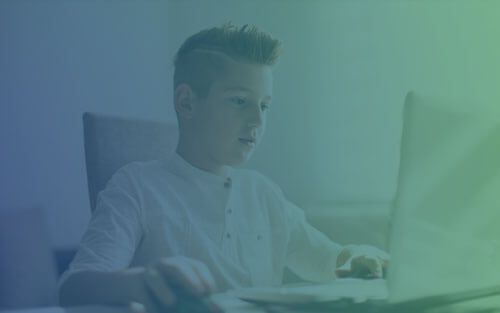 6th grade boy working on his computer during online school.